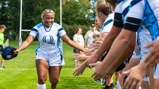 Mariah Norris-Johnson runs through high five line