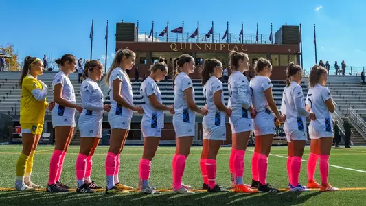 Women's soccer starting line holds hand during the national anthem against Manhattan