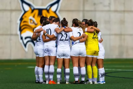 Women's soccer huddles together in a game against Niagara
