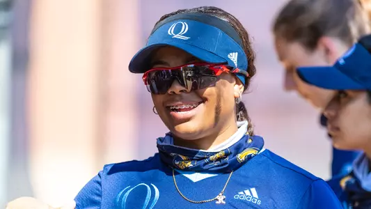 Kayla Thomas smiles while in the dugout