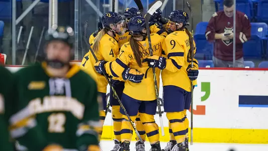 Team celebrates after scoring against Clarkson