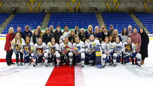 The Class of 2023 and their families pose for a photo on the ice during senior night.