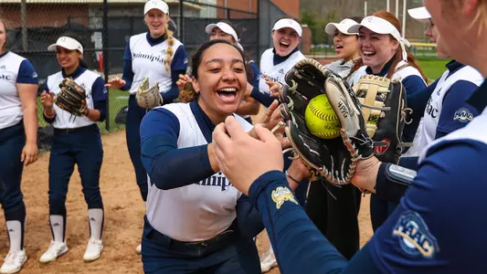 A Quinnipiac softball player runs through the starting line high-fives against Rider