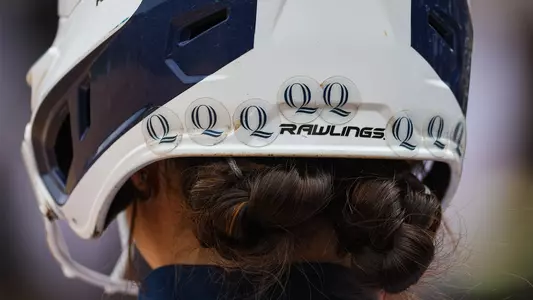 Showing the back of a player's helmet with a bunch of Q stickers for each win on the year