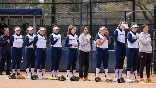 Quinnipiac softball stands on the first base line for the national anthem against Rider