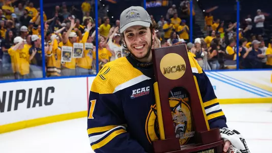 Yaniv Perets holds the NCAA Championship trophy, smiling down at a camera at the Amalie Arena in Tampa, Fla., on Tuesday, April 11, 2023.