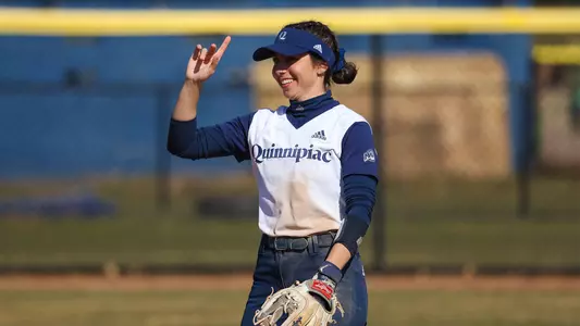 Bridget Nasir gives a peace sign while in the outfield during a game against Holy Cross