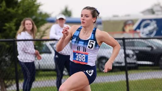 Sophomore Rylie Smith runs from right to left in her blue and white plaid Quinnipiac uniform.