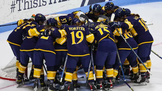 Quinnipiac women's ice hockey team huddles around the goal before a game against Colgate