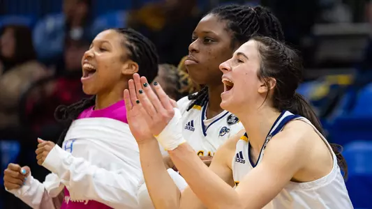 Reiven, Jackie and Tiera celebrate on the bench