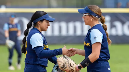 Natalia Apatiga and Ella McGalliard high five during a game against Niagara (Apr. 21, 2024)