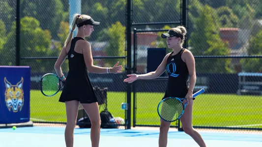 Trista Caffyn-Parsons and Ella Lewis high five after a point against UConn at home (Sept. 6, 2024)