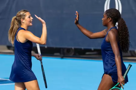 Isabella Baker and Nola Jones high-fiving in doubles against New Haven (Sept. 11, 2026 in Hamden, Conn.)