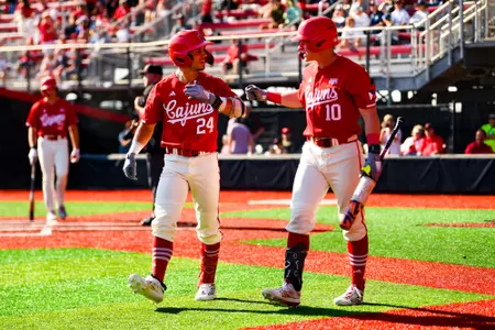 Kyle DeBarge and John Taylor high five after Kyle DeBarge home run February 25, 2024 Louisiana vs Rice Game 3 Baseball in Russo Park at M.L. "Tigue" Moore Field. Final Score Louisiana 3 Rice 0. Photo by Benjamin R. Massey/Ragin Cajun Athletics