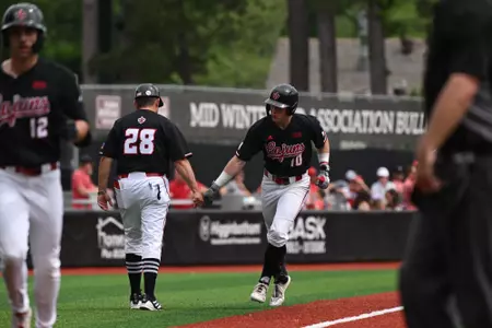 John Taylor celebrates with head coach Matt Deggs after his home run against ULM