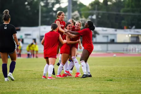 Women's soccer celebrates scoring a goal against SFA in a preseason match