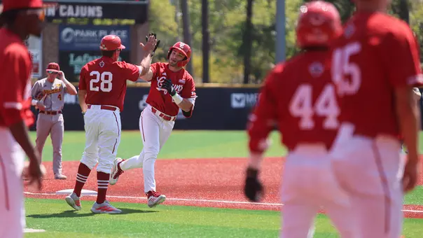 Louisiana head coach Matt Deggs (28) greets Jayce LaCava after the Ragin' Cajuns DH belted his first home run of the season in a 4-0 win over ULM on Sunday, March 29, 2026 at Russo Park