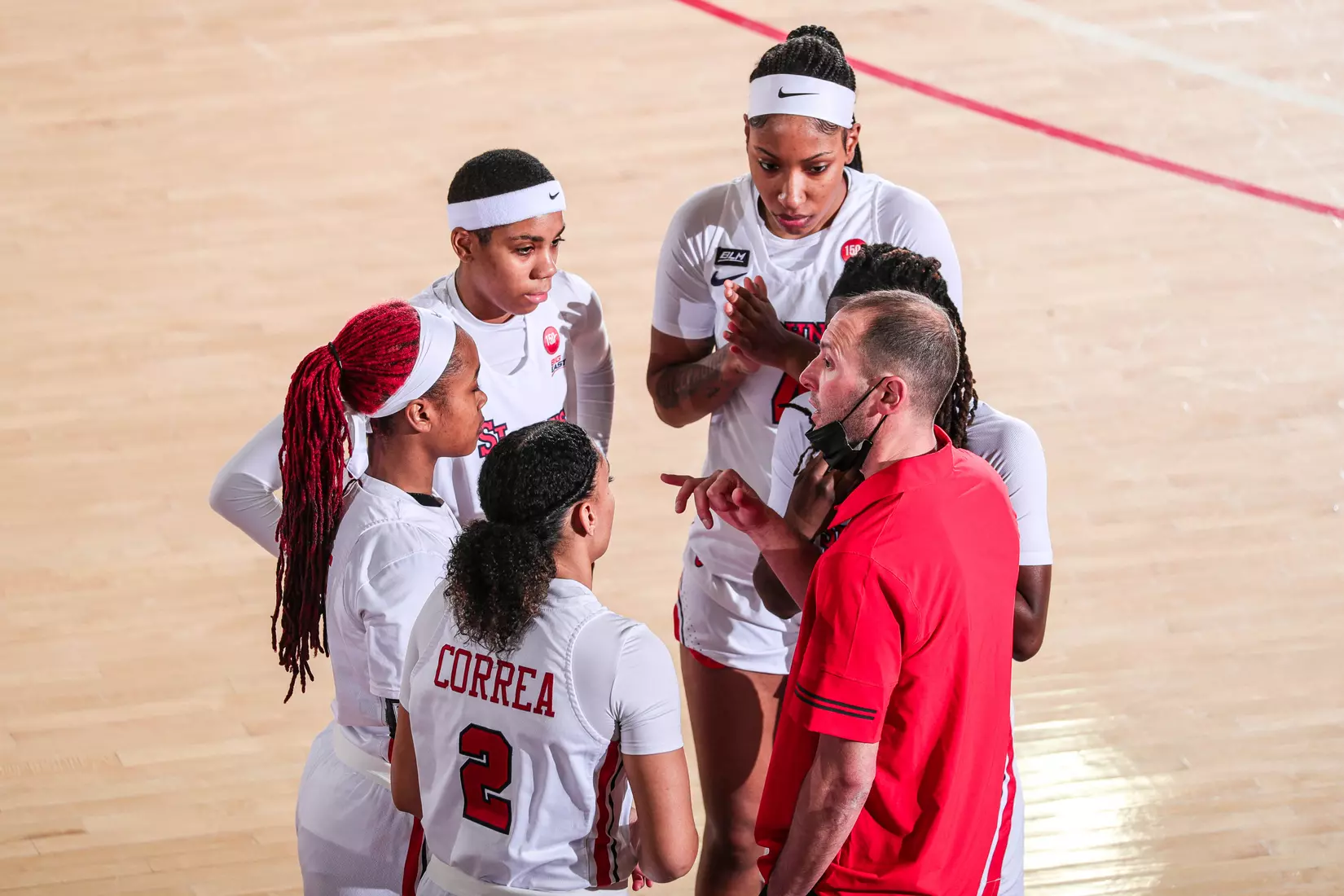 Head Coach Joe Tartamella speaks with the team as Qadashah Hoppie takes two free throws.