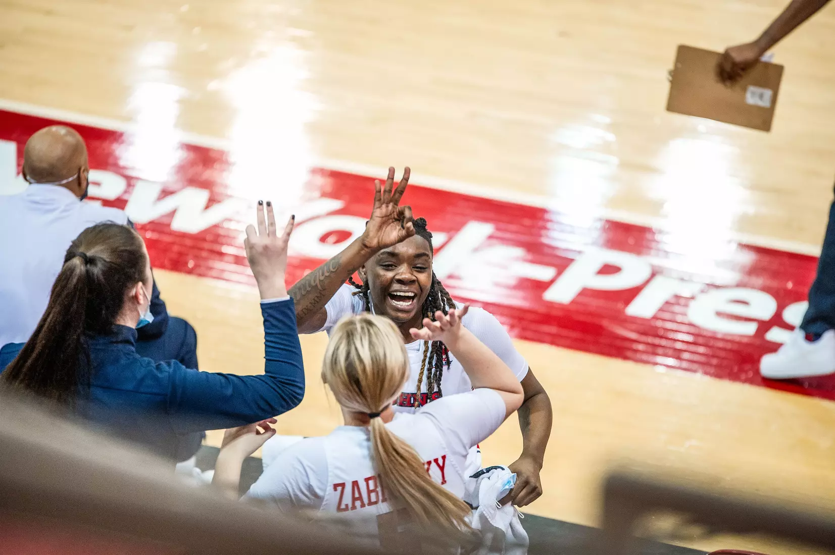 Unique Drake celebrates with Sara Zabrecky on the bench.
