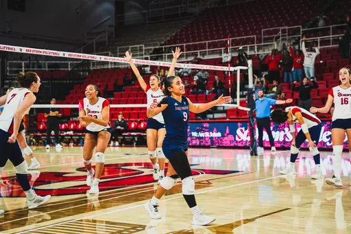 Volleyball celebrates point during 3-2 win over Providence.