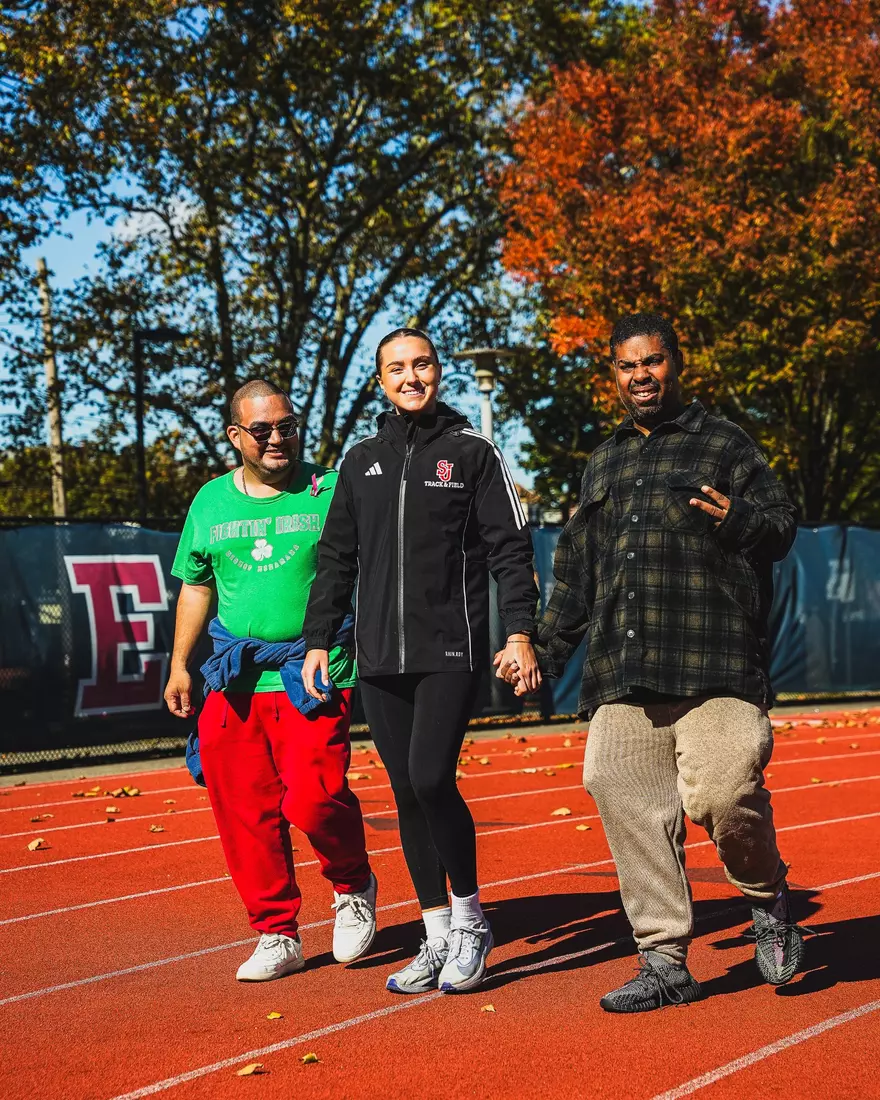 Members of QCP and SJUTF walking the track at the DaSilva Athletic Complex.
