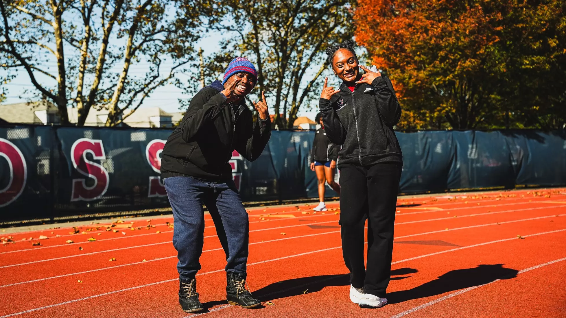 Members of QCP and SJUTF walking the track at the DaSilva Athletic Complex.