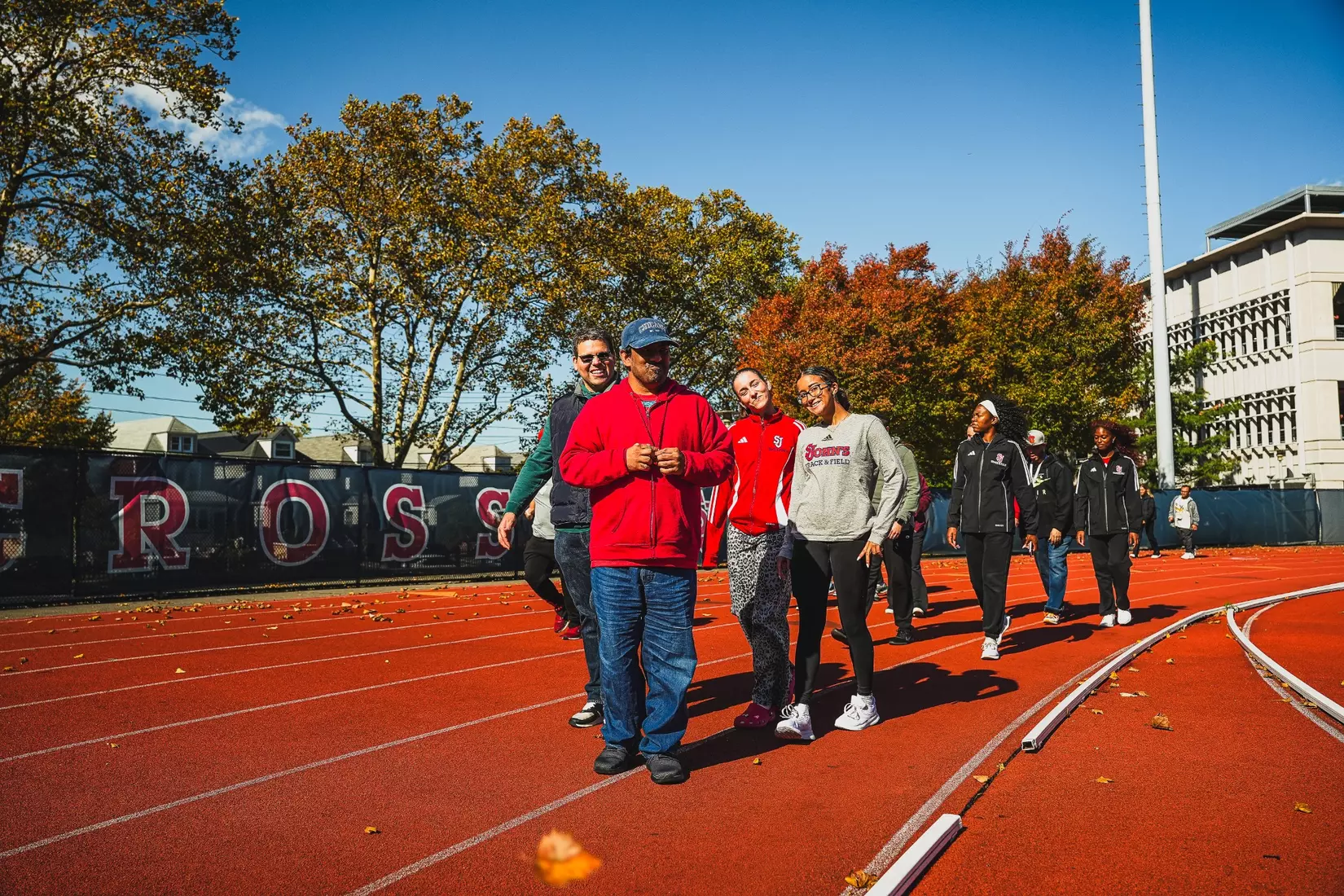 Members of QCP and SJUTF walking the track at the DaSilva Athletic Complex.
