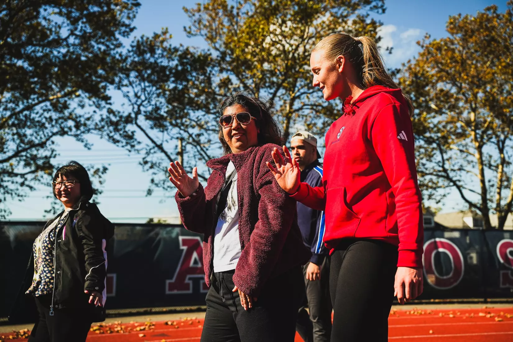 Members of QCP and SJUTF walking the track at the DaSilva Athletic Complex.