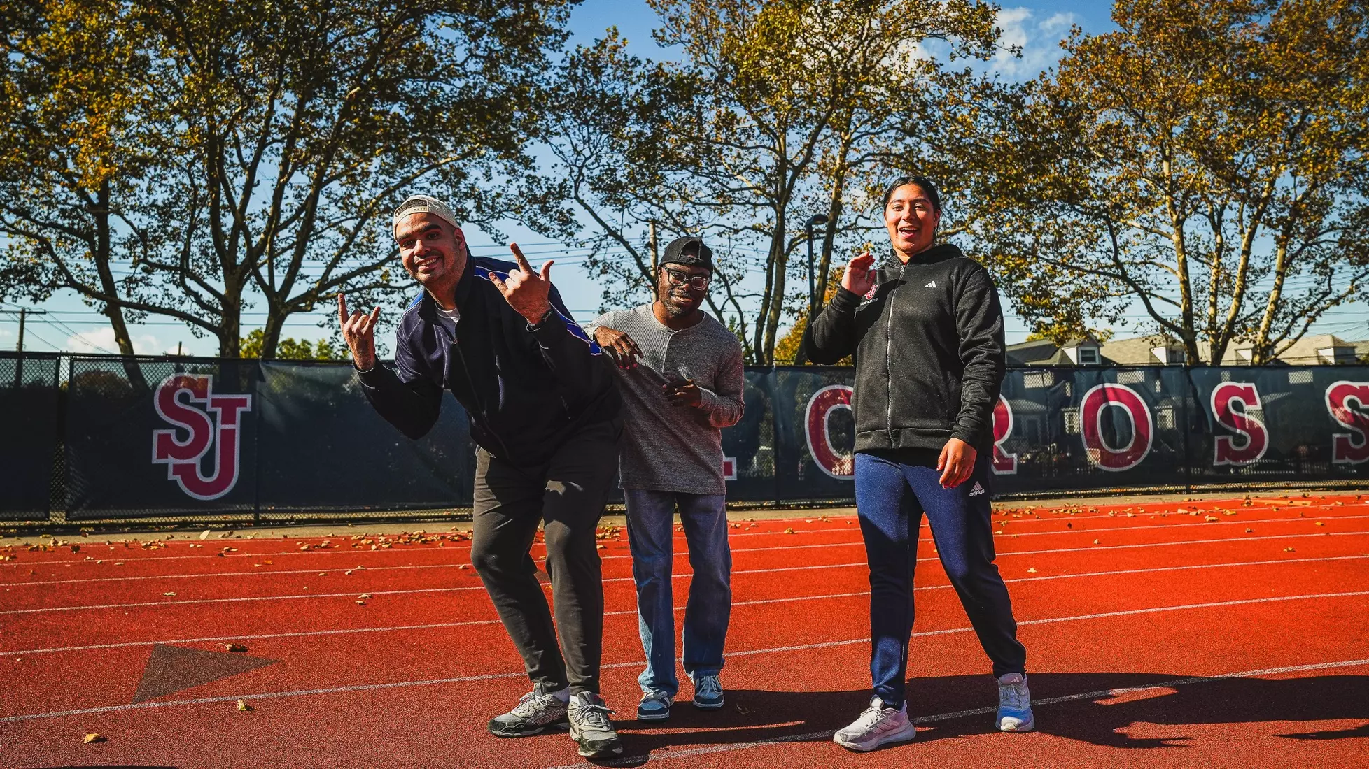 Members of QCP and SJUTF walking the track at the DaSilva Athletic Complex.