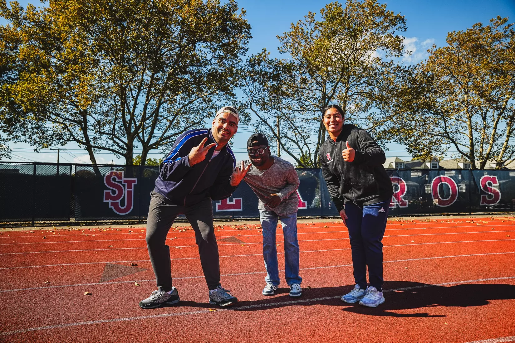 Members of QCP and SJUTF walking the track at the DaSilva Athletic Complex.
