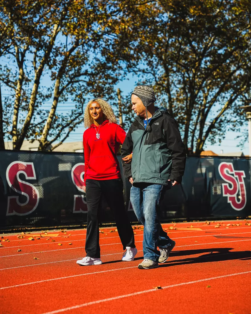 Members of QCP and SJUTF walking the track at the DaSilva Athletic Complex.