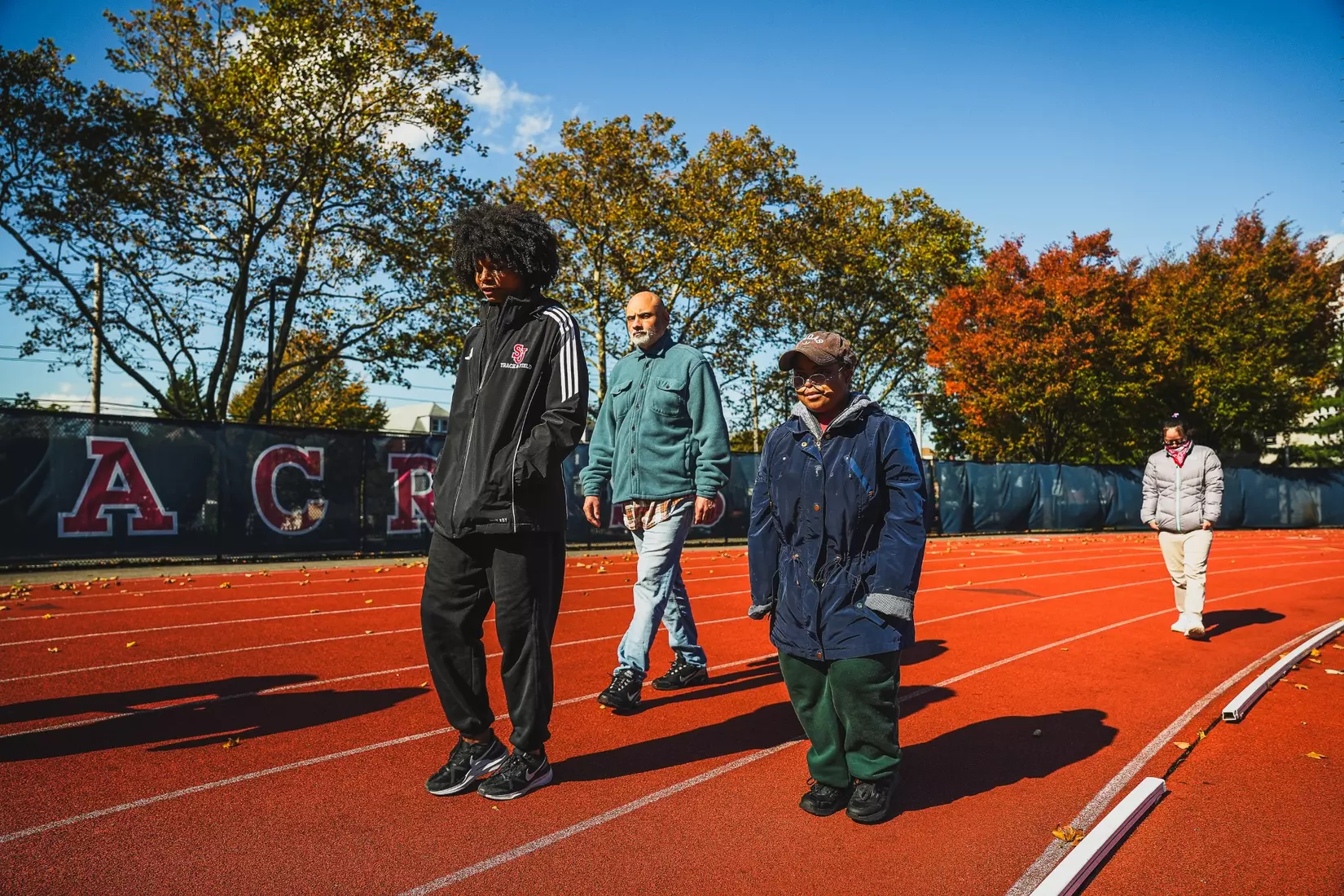 Members of QCP and SJUTF walking the track at the DaSilva Athletic Complex.