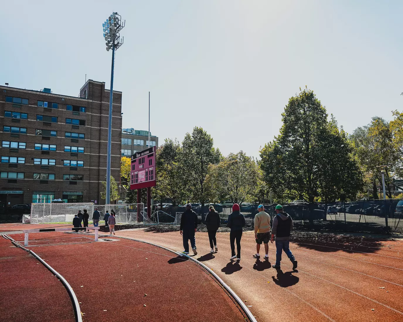 Members of QCP and SJUTF walking the track at the DaSilva Athletic Complex.