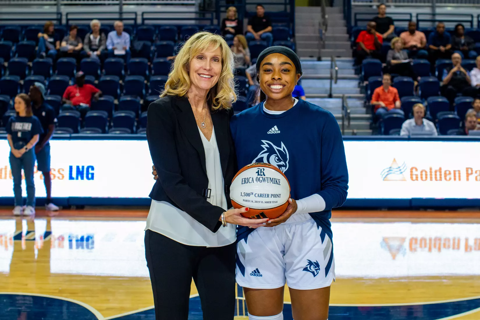 Rice head coach Tina Langley presents Erica Ogwumike with a ball commemorating her 1,500 career points.
