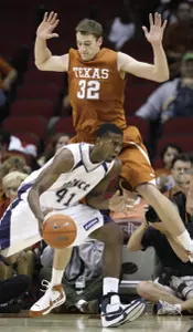 Patrick Britton, who finished with 11 points, tries to drive around Texas' Connor Atchley during the first half.