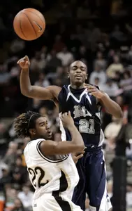 Rodney Foster passes over Vanderbilt's Jamie Graham in the first half.