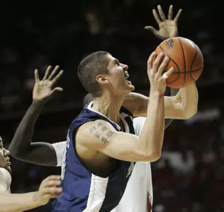 Rice forward Paulius Packevicius, front, goes up for a shot in front of Oklahoma center Longar Longar, rear, in the first half (AP Photo)