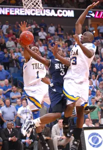 Rice freshman Tamir Jackson draws contact from both Ben Uzoh and Joe Richard during first-round action of the GMC Sierra Conference USA Championship.
