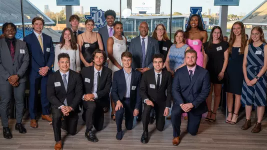 The Rice 2024 Scholar Athletes pose for a photo with Rice President Reginald DesRoches