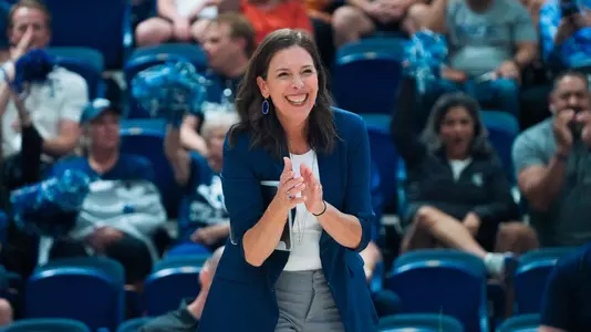 Rice head volleyball coach Genny Volpe cheers the team on during a match