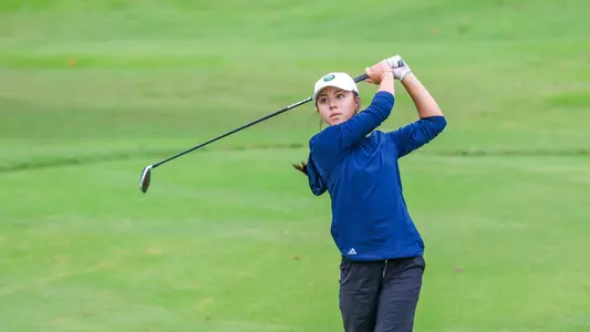 Heather Appelson watches her shot approach the green