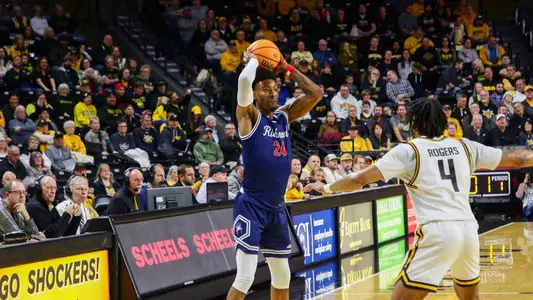 Isaiah Bigelow holds the ball over his head to throw an entry pass at Wichita State