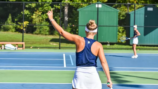 Polina Shitikova holding up a finger during a women's tennis match
