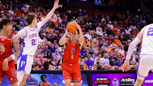 Jason Roche attempts a three-point shot vs Florida with a hand in his face