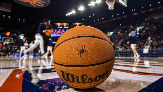 A basketball rests on the end line as the Richmond Spiders Men's Basketball team warms up in the Robins Center.
