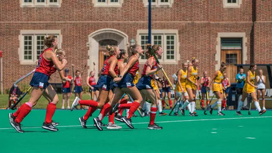 Field Hockey Players run to celebrate goal