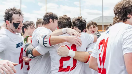 Members of the Richmond Spiders Men's Lacrosse team hug after winning the 2023 Atlantic 10 championship.