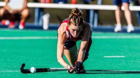 Olivia De Cain hits the ball in a low lunge sweeping motion