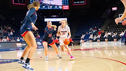 Kylee Lewandowski dribbling against a Dayton defender