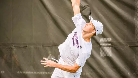 Davis Wiley hitting a serve during a tennis match